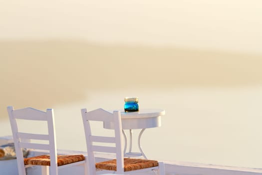 Perfect white summer villa in Firostefani, Santorini at sunset with a terrace looking at the volcano