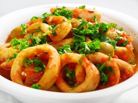 Calamari stewed in tomato and onion souces with olives, topped with parsley