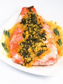 Salmon with sauce of saffron, onion and rosemary served in white plate