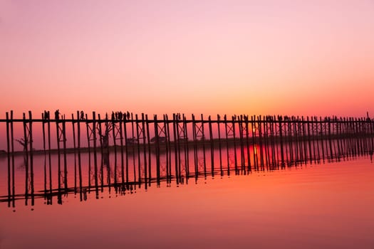 U Bein Bridge at sunset with people crossing Ayeyarwady River, Mandalay, Myanmar