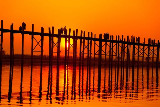 U Bein Bridge at sunset with people crossing Ayeyarwady River, Mandalay, Myanmar
