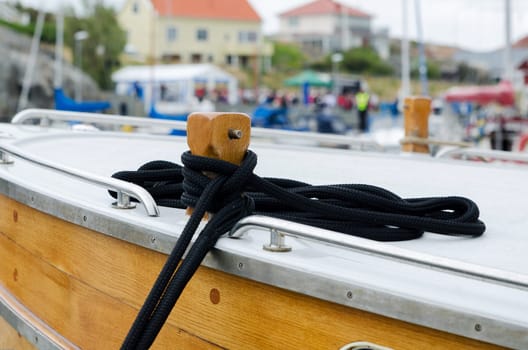 the boat is mooring with a black rope