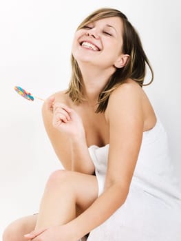 Young woman in towel with a lollipop