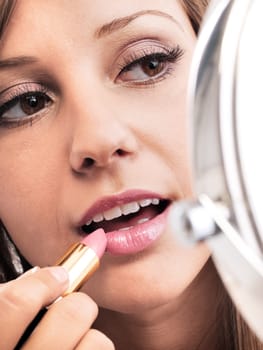 Applying make-up on young woman face, reflection in the mirror