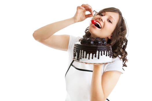 Young woman eating cherry from a chocolate cake, isolated on white
