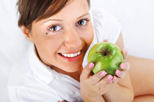 Young woman eating green apple isolated on white background