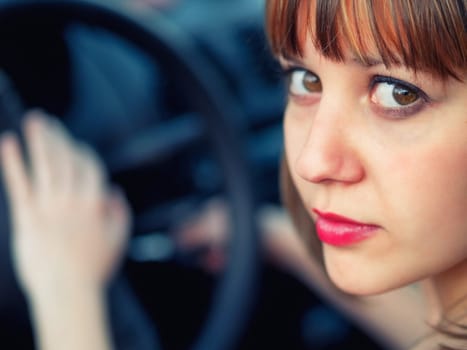 Woman driving, looking at camera