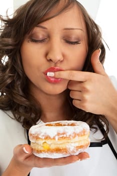Young woman as chef eating donut, close up