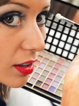 Applying make up on young woman