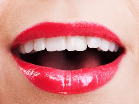 Attractive woman lips in toothy smile with red lipstick, close up