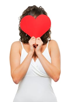 Young attractive woman holding red paper heart like a valentine card and hiding her face