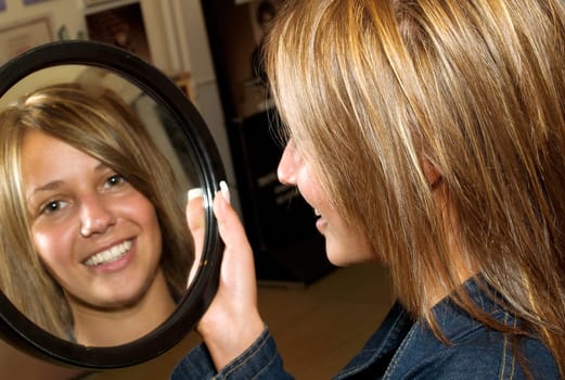 Girl with new hair-style looking herself in the mirror