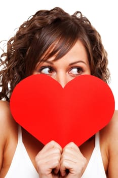 Young attractive woman holding red paper heart like a valentine card and hiding her face