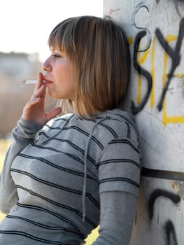 Young student smoking in front of her school