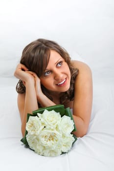 Young bride with a wedding bouquet isolated on white background looking away dreaming for future