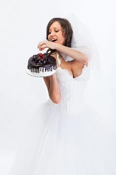 Young bride eating cake isolated on white background
