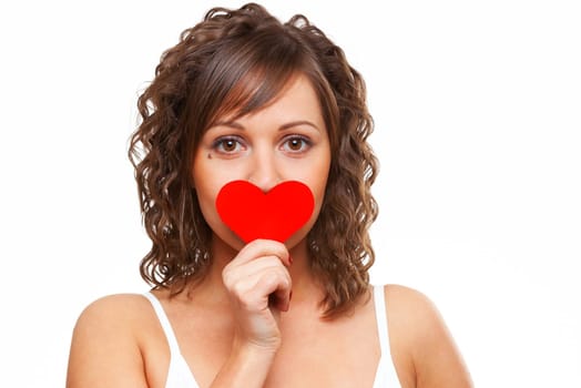 Young attractive woman holding red paper heart like a valentine card and hiding her face