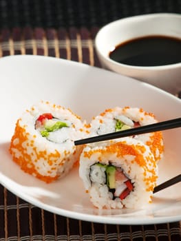 Uramaki sushi with soy sauce close up