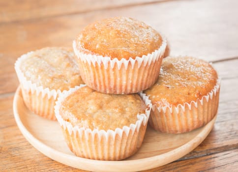 Homemade banana muffins on wooden plate, stock photo