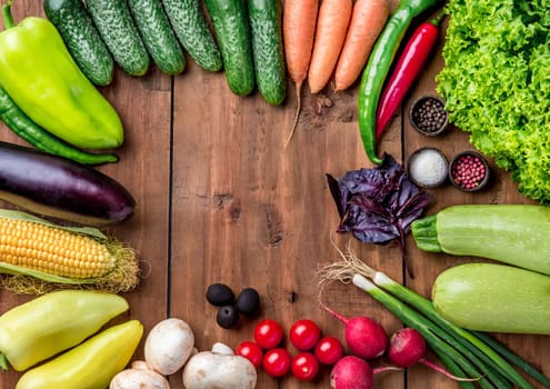 The set of multicolored vegetables, herbs and spices on wooden table, copy space image