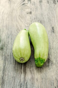 The two  green  zucchini on wooden background