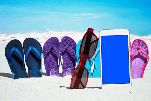 Smartphone with blank display and colorful flip flops on the beach