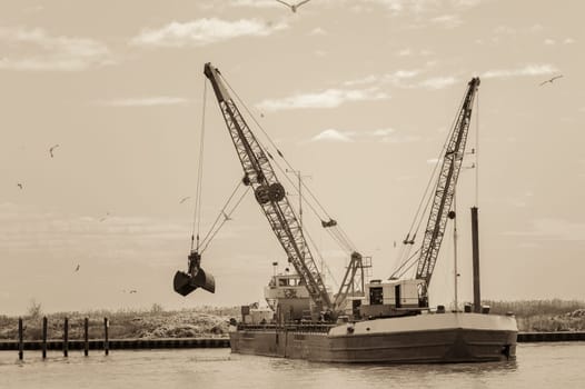 Effect vintage. Dredger ship navy working to clean a navigation channel