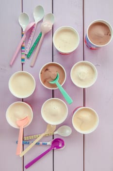 Various milk ice cream in small cups with colourful loeffeln