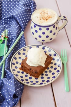 Chocolate cake with ice cream and a cup of cappuccino