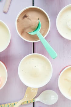 Various milk ice cream in small cups with colourful loeffeln