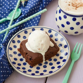 Chocolate cake with ice cream and a cup of cappuccino