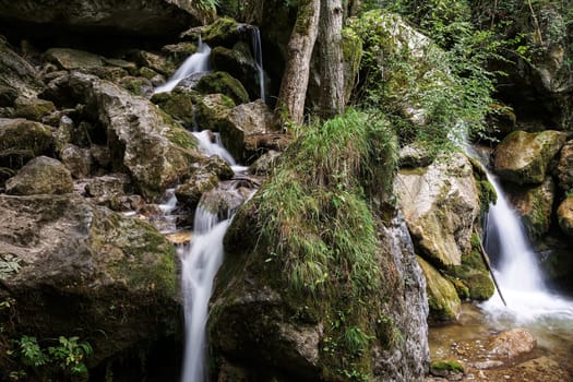 Waterfall mountain river,blurred water between stones with moss