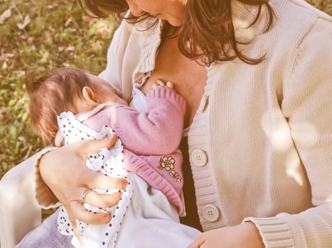 Vintage looking Pretty young brunette mum breastfeeding her baby