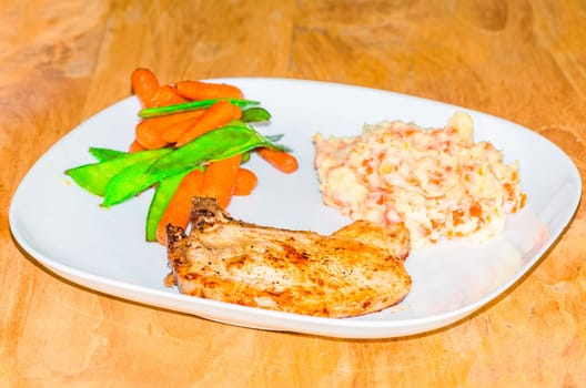 Chop with mashed potatoes with heirs,carrots and beans.