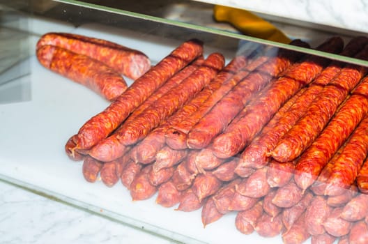 Smoked homemade sausage in the sales counter in a butcher's shop.