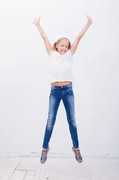 happy young girl jumping over a white background