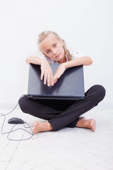 The tired young teen girl using laptop on white background