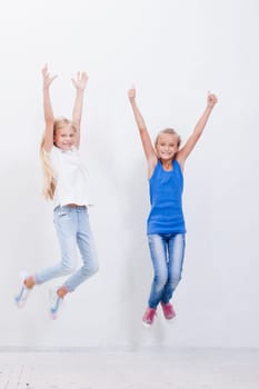 Group of happy young teens jumping over a white background