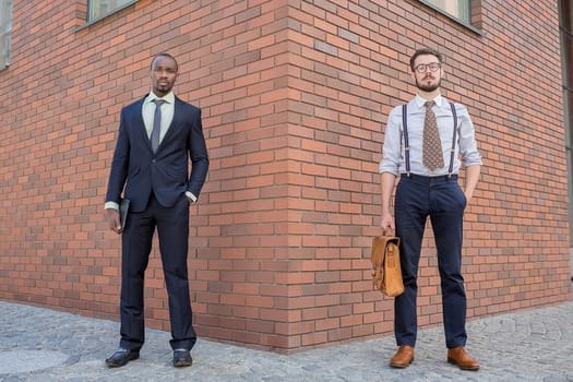 Portrait of multi ethnic business team. Two men standing against the backdrop of the city. The one man is African-American, other is European. concept of business success