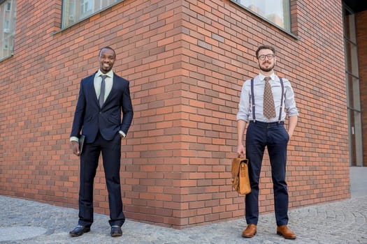 Portrait of multi ethnic business team. Two men standing against the backdrop of the city. The one man is African-American, other is European. concept of business success