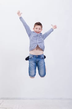 happy young boy jumping over a white background