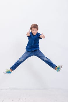 happy young boy jumping over a white background