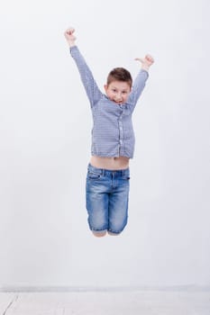 happy young boy jumping over a white background