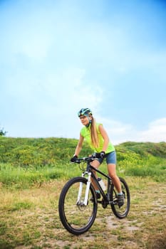 The young woman riding bicycle outside. Healthy Lifestyle. Side view
