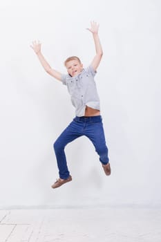 happy young boy jumping over a white background