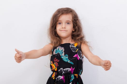 Portrait of a beautiful smiling girl showing thumbs up on white background