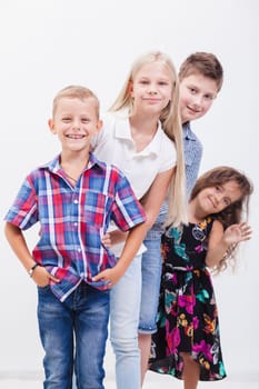 The  happy smiling teenagers standing arm in arm on white background.