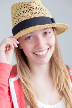 Teenage girl posing for the camera with a summer hat