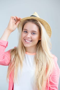 Teenage girl posing for the camera with a summer hat