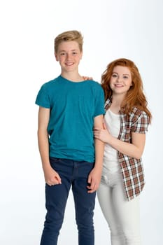 Teenage brother and sister posing together in front of a white background